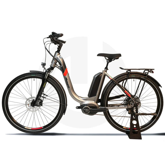 Izdelek na sliki je električno kolo znamke Malaguti, model Bolonina. Kolo ima eleganten okvir v srebrni barvi, opremljeno je z električnim motorjem Bosch in baterijo, kar omogoča enostavno vožnjo. Vidne so tudi široke gume, disk zavore ter nosilec za prtljago na zadnjem delu kolesa.