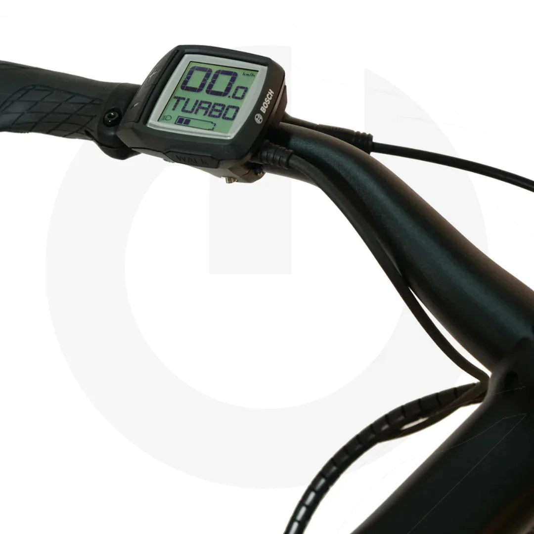 Izdelek na sliki je električno kolo znamke Malaguti, model Bolonina. Na sliki je prikazan del krmila, kjer je nameščen digitalni zaslon, ki prikazuje hitrost in način vožnje (Turbo). Zaslon je zasnovan za enostavno uporabo in omogoča spremljanje ključnih informacij med vožnjo.