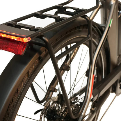 Izdelek na sliki je električno kolo znamke Malaguti, model Bolonina. Na sliki je prikazan zadnji del kolesa, kjer je vidna nosilna oprema, ki vključuje nosilec za prtljago in rdečo luč. Kolo ima široke pnevmatike in sodobno zasnovo, kar nakazuje na udobno in praktično vožnjo.