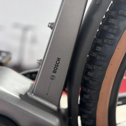 Izdelek na sliki je električno kolo, znamke Malaguti, model Carezza TR 4.0 z visokim korakom. Na sliki je vidna oznaka motorja Bosch, ki nakazuje na kakovostno električno asistenco, ter del kolesa s pnevmatiko, kar kaže na robustno zasnovo.