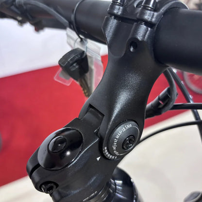 Izdelek je električno kolo znamke Malaguti, model Carezza TR 4.0 High Step. Na sliki je prikazan del krmila, ki vključuje nastavljiv spojnik ter ključ, kar nakazuje na funkcionalnosti in možnosti prilagoditve kolesa. Ozadje je rdeče, kar daje dodatno vizualno privlačnost.