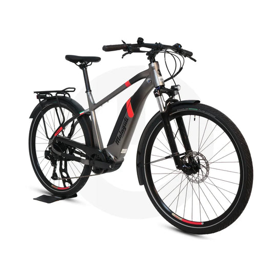 Izdelek na sliki je električno kolo, znamke Malaguti, model Carezza TR 4.0 High Step. Kolo ima moderno zasnovo, s poudarjenim okvirjem in diskastimi zavorami. Vidna sta tudi zadnji prtljažnik in široka kolesa, kar nakazuje na udobno vožnjo po različnih terenih. Barvna kombinacija vključuje sivo in rdeče detajle, kar daje kolesu športen videz.