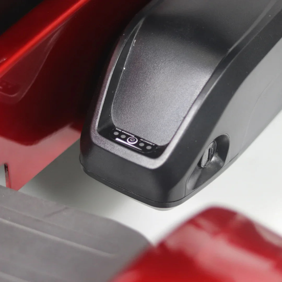 Izdelek je električni mobilni voziček, model Mijo MD08. Na sliki je vidna baterija vozička, ki ima indikator napolnjenosti. Barva vozička je rdeča, kar daje sodoben in privlačen videz.