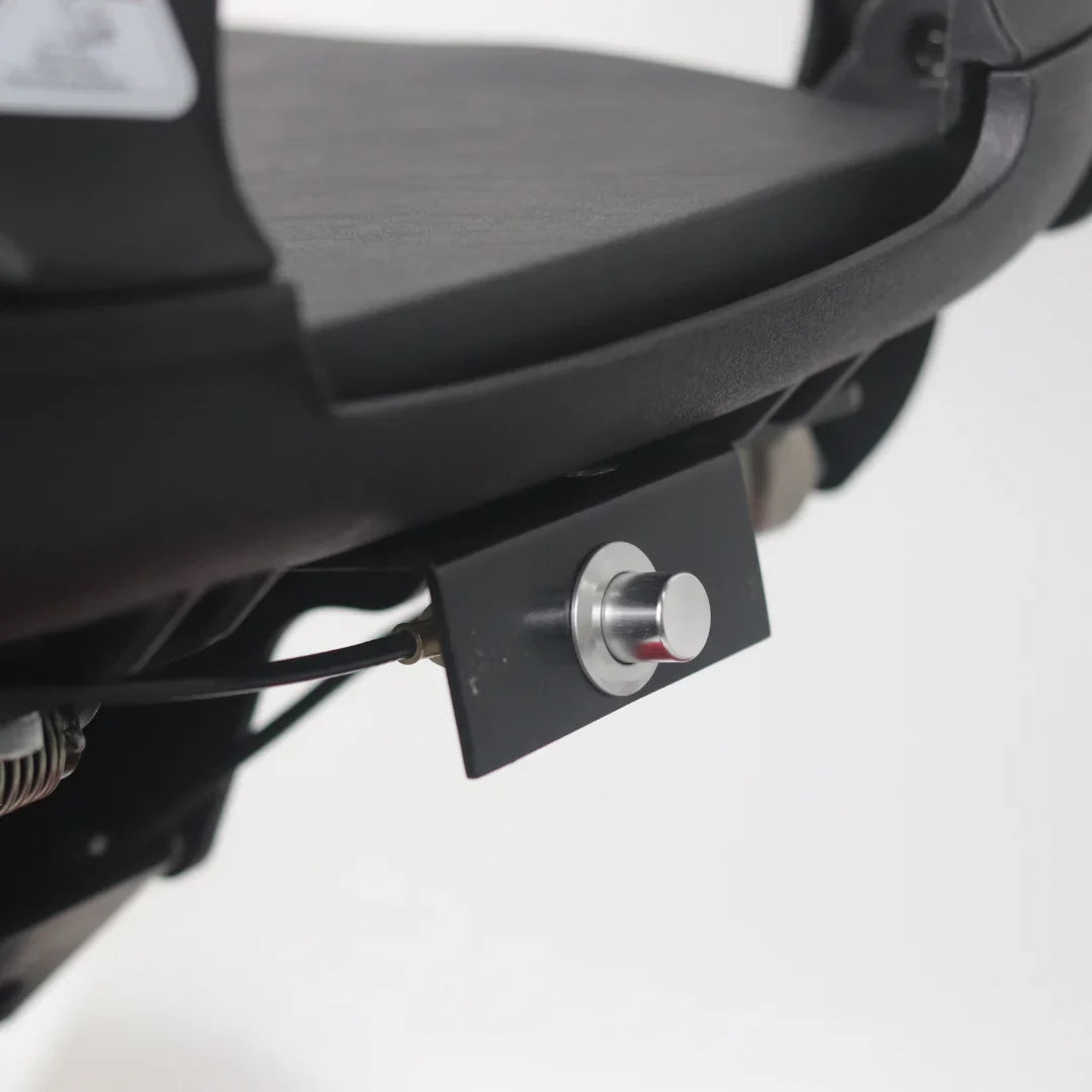 Izdelek je električni mobilni voziček, model Mijo MD08. Na sliki je prikazan del vozička, kjer je vidna podpora za sedež in gumb, verjetno za upravljanje ali aktivacijo funkcij vozička. Celotna konstrukcija je zasnovana za udobno in enostavno uporabo.