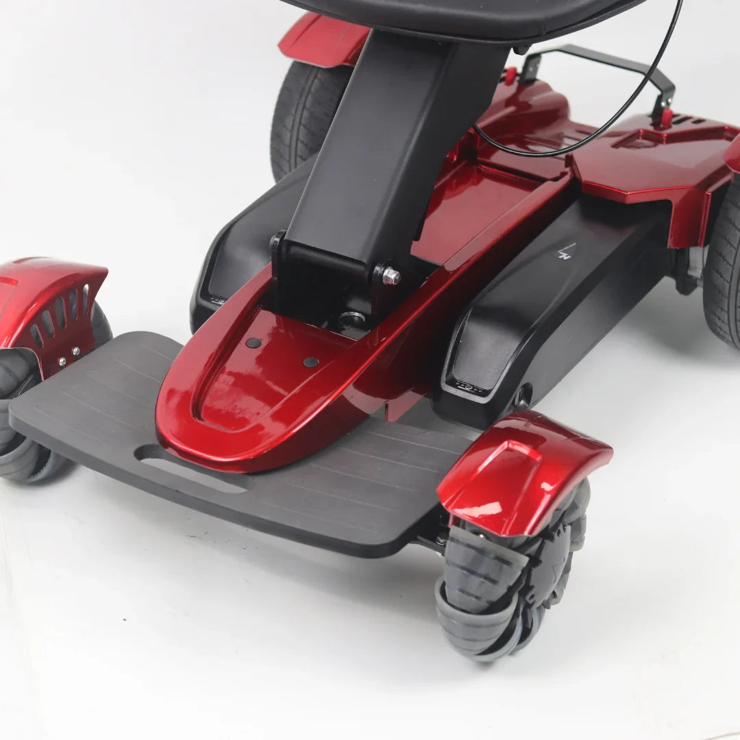 Izdelek je električni mobilni voziček, model Mijo MD08. Na sliki je prikazana spodnja polovica vozička, ki vključuje široko podnožje in sprednje ter zadnje kolesa. Voziček je v rdeči barvi, kar mu daje privlačen videz. Kolesa so zasnovana za dobro stabilnost in manevriranje.