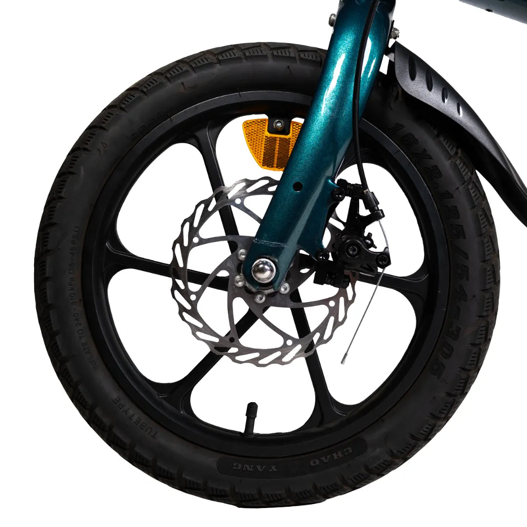 Izdelek je električno kolo, model MS Energy Urbanfold i6. Na sliki je vidna sprednja kolesa, ki vključuje disk zavore in pnevmatiko z značilnim profilom. Barva okvirja je modra, kar daje kolesu sodoben videz. Kolo je zasnovano za urbano vožnjo, kar je razvidno iz njegove kompaktne oblike in dodatkov, kot so odsevniki za večjo varnost.