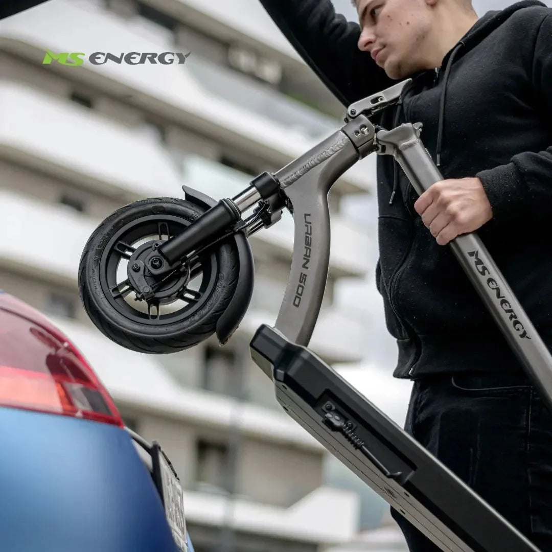 Oseba dvigne električni skiro Ms Energy Urban 500 v prtljažnik avtomobila.