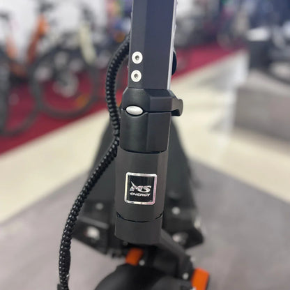 Izdelek je električni skiro, model MS Energy Flare X Pro. Na sliki je prikazan del skiroja, osredotočen na ročaj in mehanizem za zlaganje, ki je črn in ima značilno oznako znamke MS Energy. V ozadju so vidni drugi kolesi, kar nakazuje, da je skiro postavljen v prodajnem prostoru.