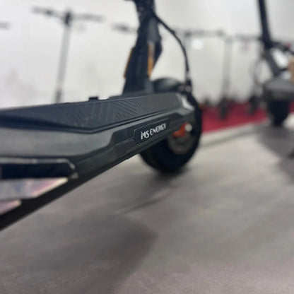 Na sliki je električni skiro znamke MS Energy, model Flare X Pro. Vidna je podlaga skiroja z značilnim vzorcem in logotipom MS Energy. V ozadju so še drugi električni skiroji, kar nakazuje, da gre za prodajno ali razstavno okolje.