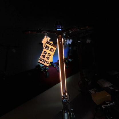 Izdelek na sliki je električni skiro, model MS Energy Flare X Pro. Na sliki je vidna sprednja stran skiroja z osvetlitvijo, ki se razteza po ročaju. Ob skiroju je priložena oznaka z navodili in simboli, ki prikazujejo različne funkcije in možnosti uporabe. V ozadju so vidni tudi drugi skiroji, kar nakazuje, da gre za razstavo ali trgovino.