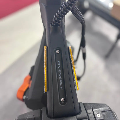 Izdelek je električni skiro, model MS Energy Flare X Pro. Na sliki je vidna ročica skiroja s prepoznavnim logotipom MS Energy ter odsevniki, ki povečujejo varnost pri vožnji. Oprema je zasnovana za udobno in varno vožnjo.