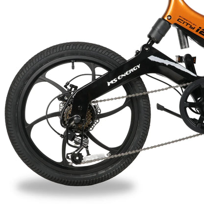 Izdelek na sliki je električno kolo, znamke MS Energy, model i20. Na sliki je prikazan zadnji del kolesa, ki vključuje črno kolo z večkrakim dizajnom, menjalnik in verigo. Vidna je tudi oznaka znamke MS Energy na okvirju. Kolo ima široke pnevmatike, kar nakazuje na stabilnost in udobje med vožnjo.