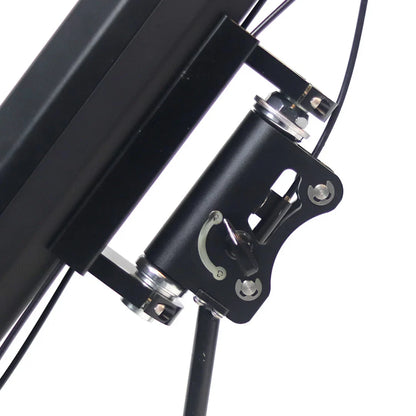 Izdelek na sliki je električni priklop, model Mijo MT01. Na sliki je prikazan del priklopa, ki vključuje kovinski mehanizem in povezovalne elemente. Vidni so tudi kabli, kar nakazuje na električno povezavo. Celoten dizajn je minimalističen in funkcionalen.