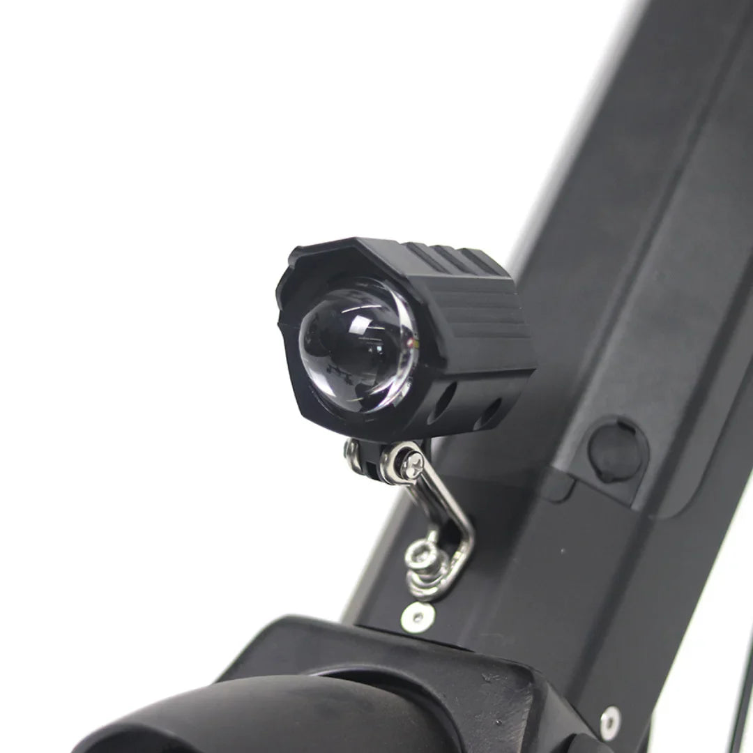 Izdelek je električni priklop, model Mijo MT01. Na sliki je prikazan del električnega skiroja z nameščeno lučko, ki je zasnovana za izboljšanje vidnosti med vožnjo. Lučka je črne barve in je pritrjena na okvir skiroja, kar nakazuje na funkcionalnost in praktičnost pri nočni vožnji.