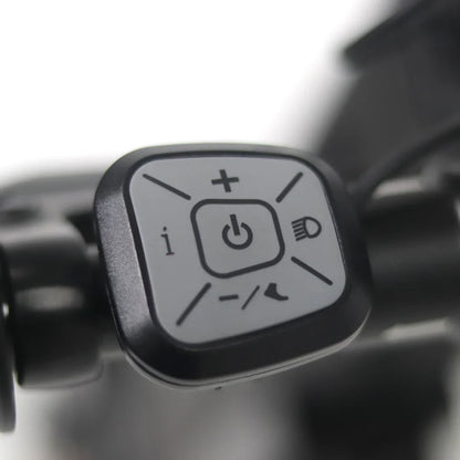 Na sliki je prikazan del električnega skiroja, model Mijo MT01. Vidna je kontrolna enota s tremi gumbi, ki vključujejo gumb za vklop, gumb za povečanje in zmanjšanje hitrosti ter gumb za luči. Kontrolna enota je zasnovana za enostavno upravljanje funkcij skiroja.