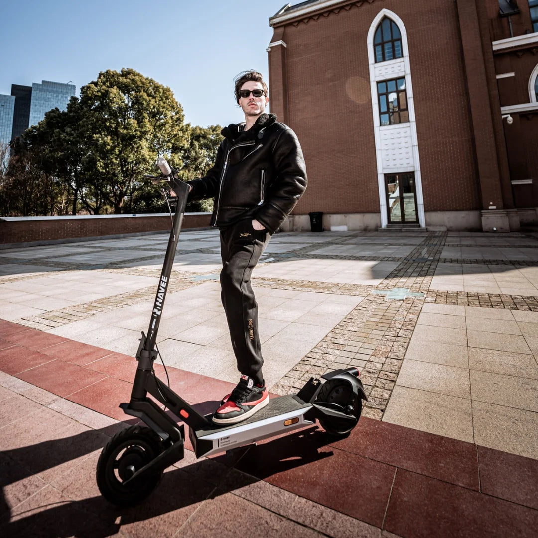 Oseba stoji na električnem skiroju Navee S40 v urbanem okolju.