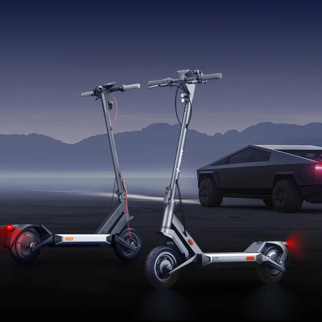 Dva električna skiroja Navee S40 parkirana v bližini futurističnega vozila ob somračni pokrajini.
