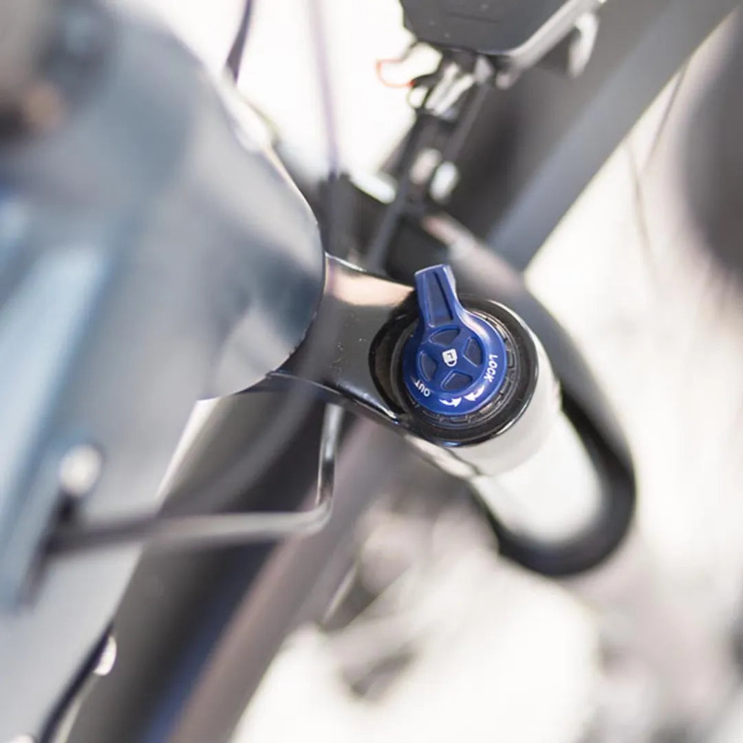 Od blizu posnet detajl komponente na električnem kolesu Puch C 5 5, ki prikazuje moder gumb za nastavitev.