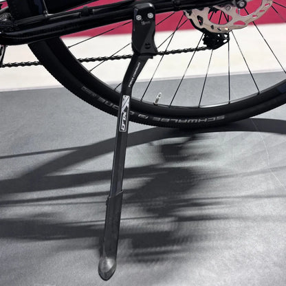 Izdelek na sliki je električno kolo, znamke Raymon, model GravelRay E 7.0. Na sliki je vidna nogica kolesa, ki je pritrjena na okvir, ter del kolesa s pnevmatiko, ki ima oznako Schwalbe. Kolo je zasnovano za gravel vožnjo, kar pomeni, da je primerno za različne terene.