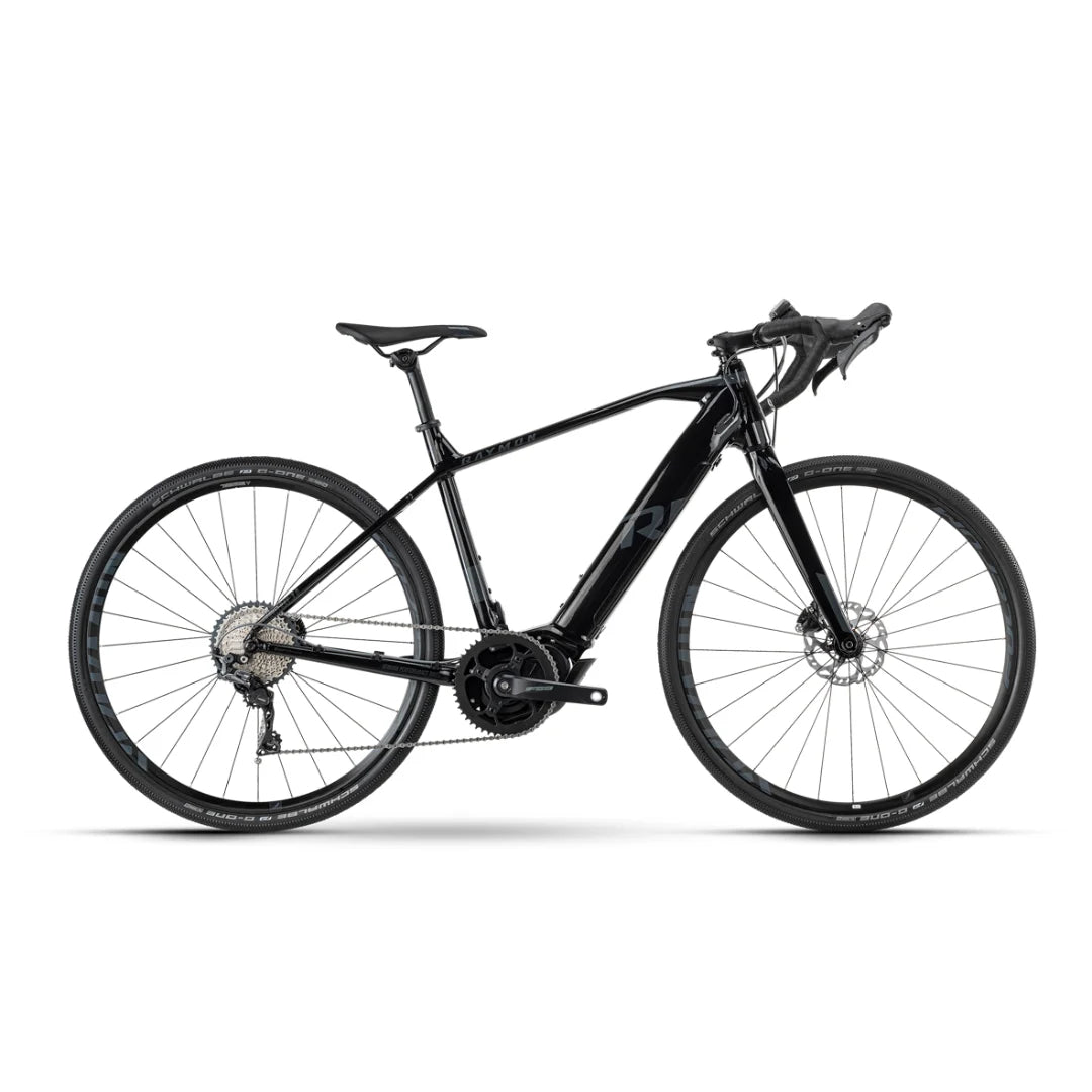 Izdelek je električno kolo, znamke Raymon, model GravelRay E 7.0. Na sliki je vidno elegantno črno kolo z aerodinamično zasnovo, opremljeno z disk zavornim sistemom in širokimi pnevmatikami, kar omogoča vožnjo po različnih terenih. Kolo ima športne ročke in sodobno prestavno napravo, kar nakazuje na njegovo zmogljivost in udobje pri vožnji.