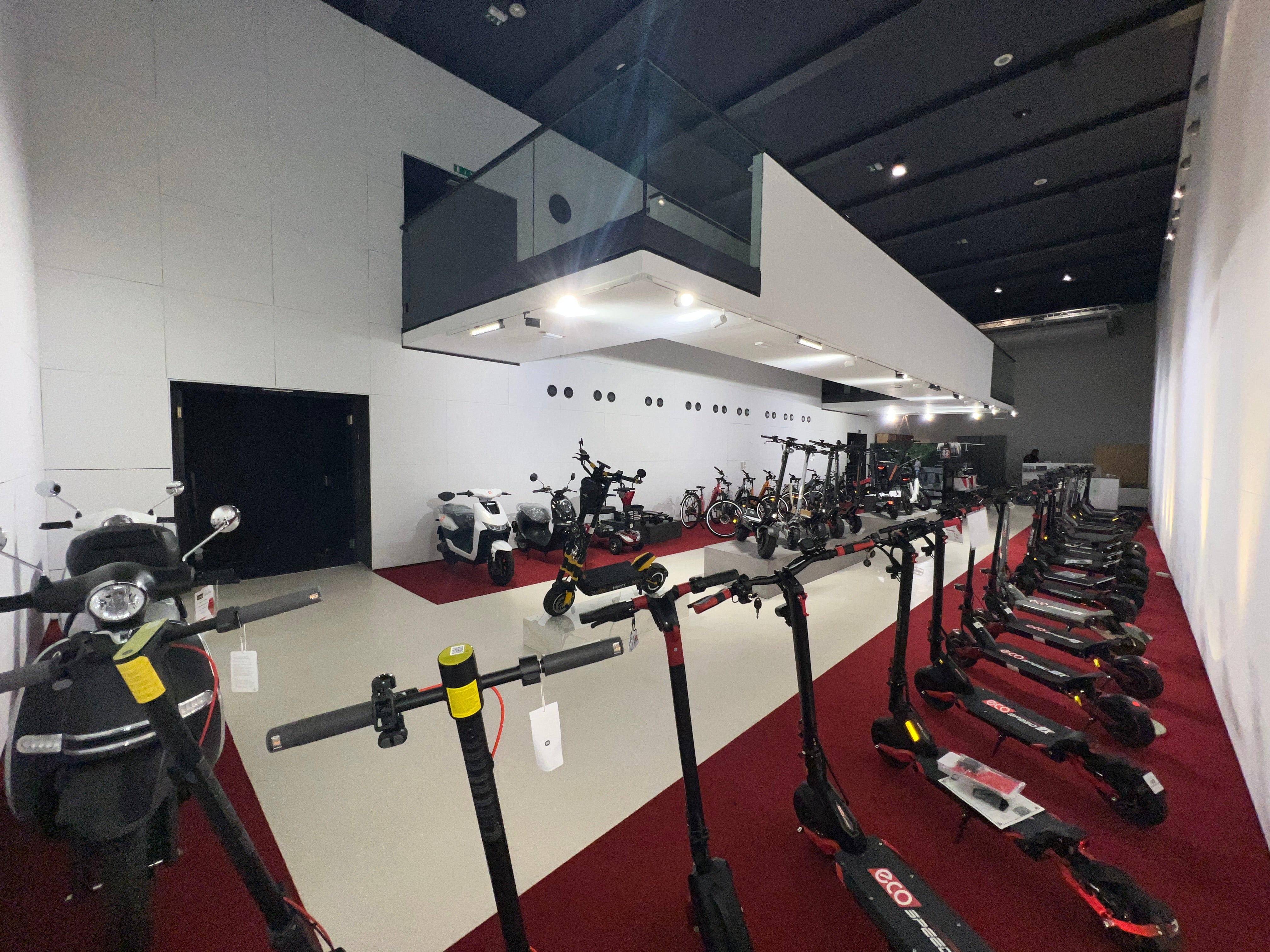 Display of electric scooters in a showroom setting with a modern interior.