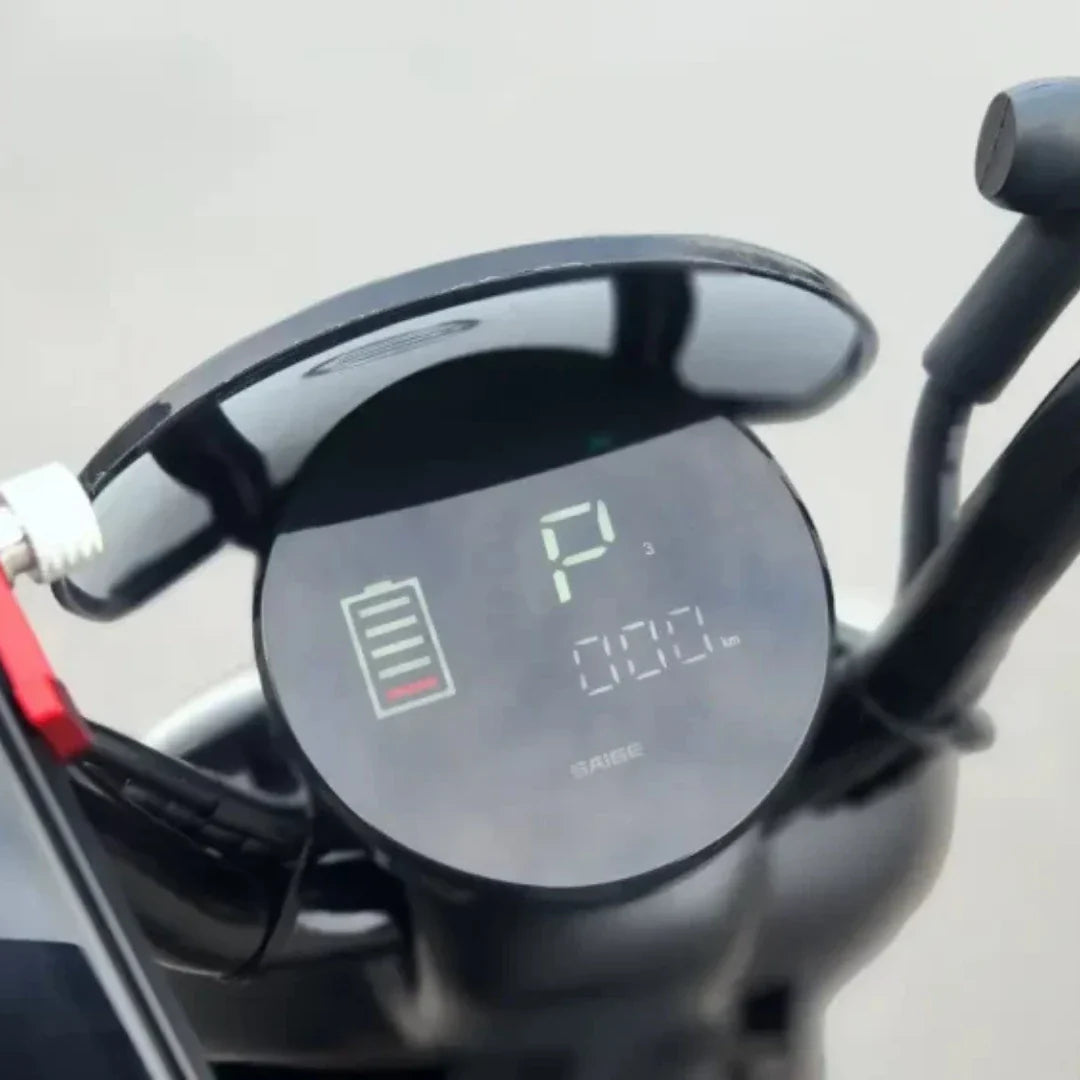 Na sliki je prikazan električni motocikel, model "Stromko". Vidna je digitalna armaturna plošča, ki prikazuje stanje baterije in prevoženo razdaljo. Na zaslonu je označeno, da je motocikel v načinu parkiranja (P), kar nakazuje, da je trenutno ustavljen. Zaslon je sodobne oblike in se nahaja na krmilu motocikla.