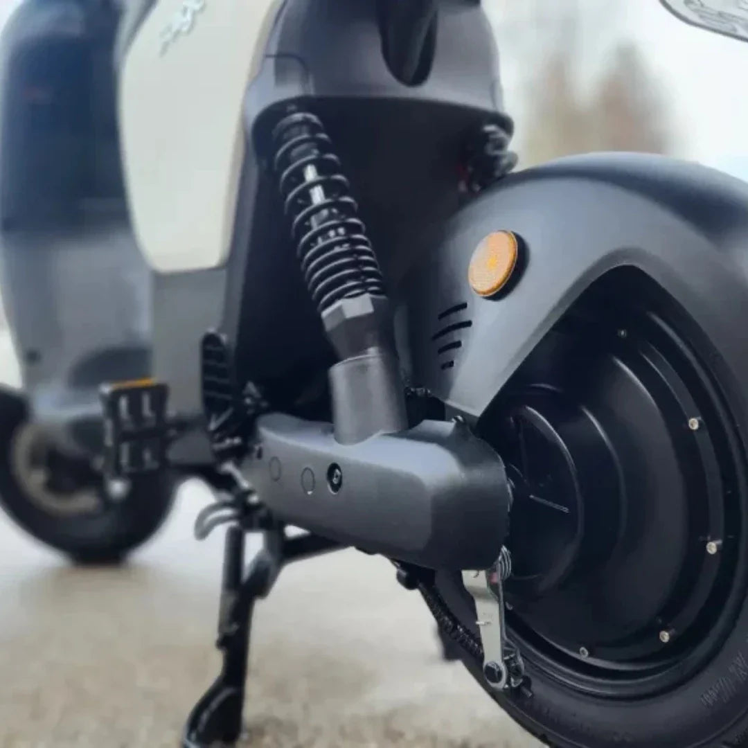 Izdelek na sliki je električna motorna kolesa, verjetno model znamke Stromko. Na sliki je vidna zadnja stran motorja, kjer so prikazani amortizerji, kolesni mehanizem in del električnega motorja. Oprema je moderna in zasnovana za udobno vožnjo, kar nakazuje na kakovostno izdelavo.