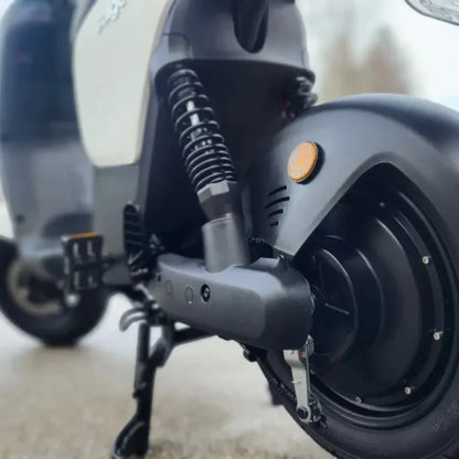 Izdelek na sliki je električna motorna kolesa, verjetno model znamke Stromko. Na sliki je vidna zadnja stran motorja, kjer so prikazani amortizerji, kolesni mehanizem in del električnega motorja. Oprema je moderna in zasnovana za udobno vožnjo, kar nakazuje na kakovostno izdelavo.