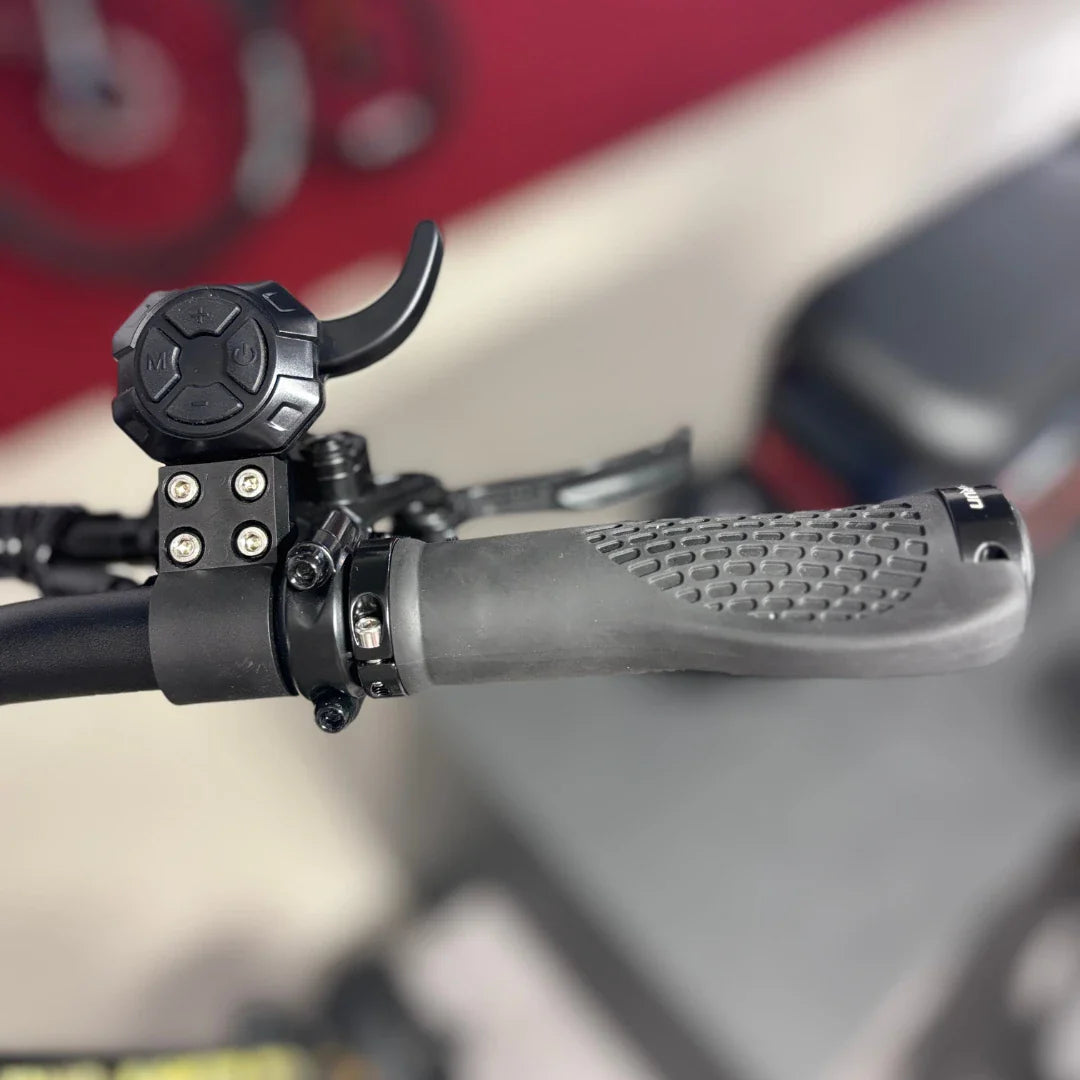 Na sliki je električni skiro znamke Teverun, model Fighter Mini Pro 2025. Vidni so ročaji skiroja s teksturirano površino za boljši oprijem ter kontrolni gumb, ki omogoča upravljanje hitrosti ali načina vožnje. Ozadje je nevtralno, kar poudarja detajle na skiroju.