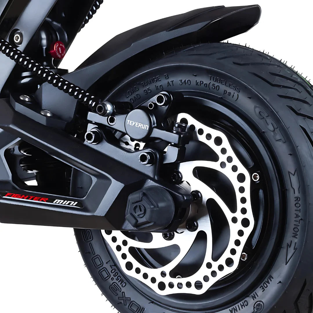 Na sliki je prikazan električni skiro, model Teverun Fighter Mini Pro 2025. Vidna je zadnja kolesna enota, ki vključuje disk zavora in pnevmatiko z oznako CST. Zasnova je moderna in robustna, kar nakazuje na dobro zmogljivost in stabilnost pri vožnji. Oprema vključuje tudi vzmetenje, kar prispeva k udobni vožnji.