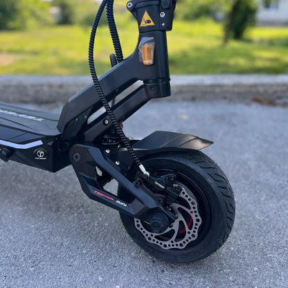 Izdelek na sliki je električni skiro, model Teverun Fighter Mini Pro iz leta 2025. Na sliki je prikazan del sprednjega dela skiroja, vključno s kolesom, zavorami in okvirjem. Vidna je tudi oznaka znamke Teverun ter detajli, ki kažejo na robustno konstrukcijo in kakovostne komponente. Kolo ima široko pnevmatiko in disk zavore, kar nakazuje na dobro zmogljivost in stabilnost.