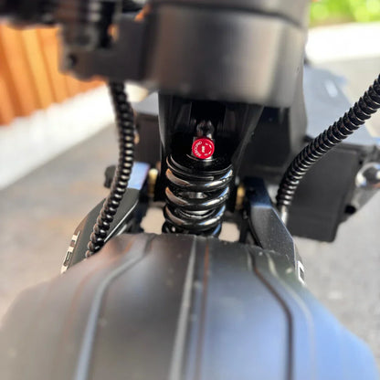 Izdelek je električni skiro, znamke Teverun, model Fighter Supreme 7260 Ultra. Na sliki je vidna podrobnost vzmetnega sistema, ki vključuje črno vzmet in rdeč indikator, ki označuje nastavitev. V ozadju se vidi del strukture skiroja, kar nakazuje na robustno zasnovo.