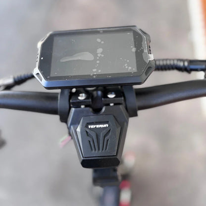 Izdelek na sliki je električni skiro znamke Teverun, model Fighter Supreme 7260 Ultra. Na sliki je prikazano krmilo skiroja z digitalnim zaslonom, ki prikazuje informacije o vožnji. Zaslon je zaščiten z robom in je nekoliko umazan, kar kaže na uporabo. Pod zaslonom je vidna tudi oznaka znamke Teverun.