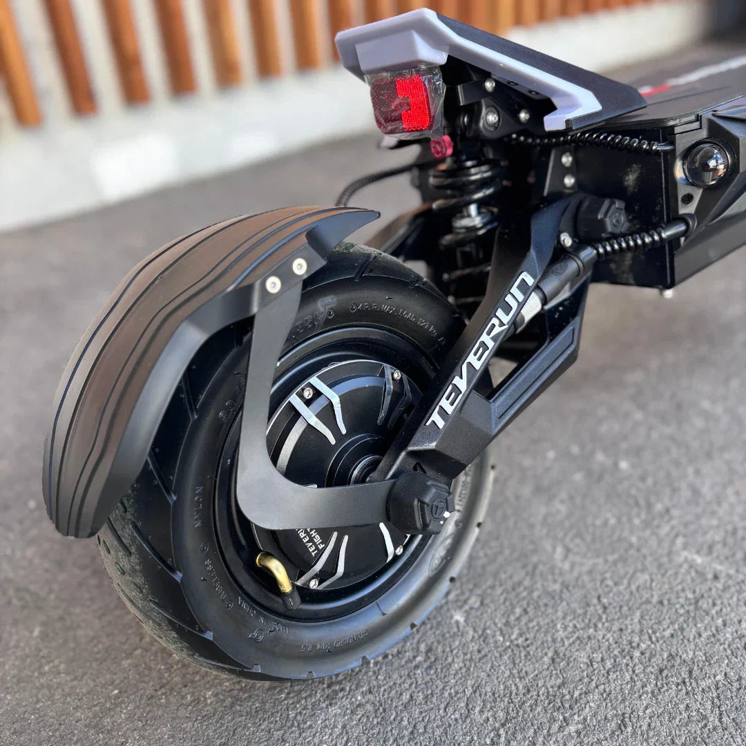 Izdelek je električni skiro, znamke Teverun, model Fighter Supreme 7260 Ultra. Na sliki je prikazan zadnji del skiroja, kjer je vidna velika pnevmatika, motor, ter zaščitni blatnik. Opremljen je tudi s svetilko, ki je nameščena na zadnjem delu. Skupna zasnova nakazuje na robustnost in zmogljivost skiroja.