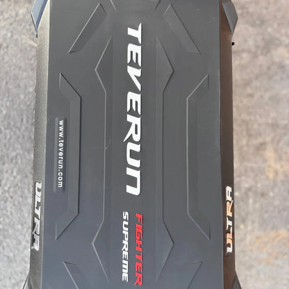 Izdelek je električni skiro, znamke Teverun, model Fighter Supreme ULTRA. Na sliki je vidna zgornja površina skiroja, ki ima črno teksturo z izbočenimi vzorci ter napisom "TEVERUN" in "FIGHTER SUPREME ULTRA" v različnih barvah. Površina je zasnovana za dober oprijem, kar je pomembno za varno vožnjo.