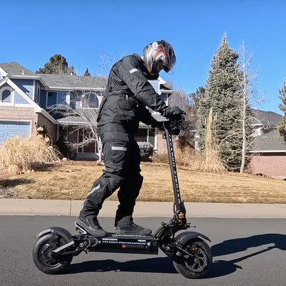 Voznik v opremi vozi električni skiro Teverun Fighter Supreme 7260r po primestni ulici.