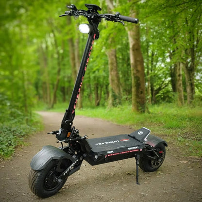 Električni skiro Teverun Fighter Supreme 7260r parkiran na gozdni poti, obdani z zelenjem.