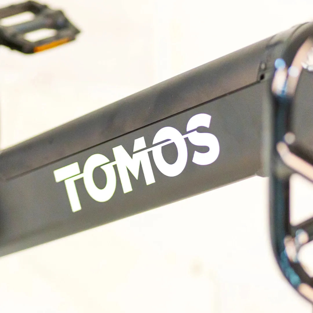 Posnetek od blizu okvirja, ki prikazuje logotip električnega kolesa Tomos Cargo Fat 2 Longtail.