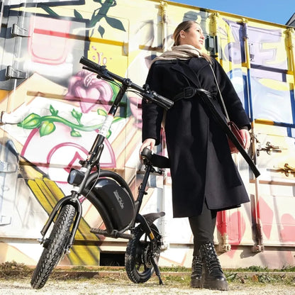 Ženska stoji ob električnem kolesu Urbanglide 160 pred pisano steno z grafiti.