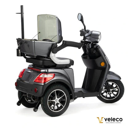 Izdelek na sliki je električni skuter, model Veleco Draco. Na sliki je prikazan skuter v temno sivi barvi, opremljen z udobnim sedežem in prostornim prtljažnikom na zadnji strani. Ima široke kolesa, kar zagotavlja stabilnost, ter je zasnovan za enostavno upravljanje in udobno vožnjo.