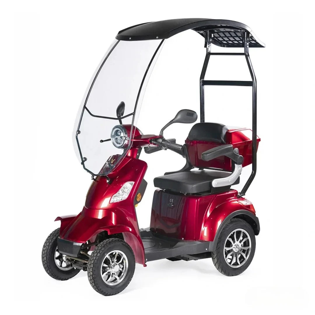 Izdelek na sliki je električni skuter, specifično model Veleco Faster. Na sliki je vidna rdeča električna vozila s tremi kolesi, ki ima zaščitni pokrov nad sedežem in volanom. Skuter je zasnovan za udobno vožnjo, kar omogočata široka sedeža in ergonomski ročaji. Sprednji del vključuje vetrobransko steklo, kar dodatno ščiti voznika pred vremenskimi vplivi.