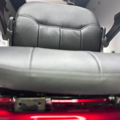 Izdelek na sliki je električni skuter s tremi kolesi, model Vigorous Vista 1. Na sliki je prikazan sedež, ki je oblazinjen s črnim usnjem, kar nakazuje na udobno vožnjo. Sedež ima ergonomsko obliko in je zasnovan za udobno sedenje med vožnjo. Vidna je tudi struktura pod sedežem, kar kaže na robustno konstrukcijo skuterja.