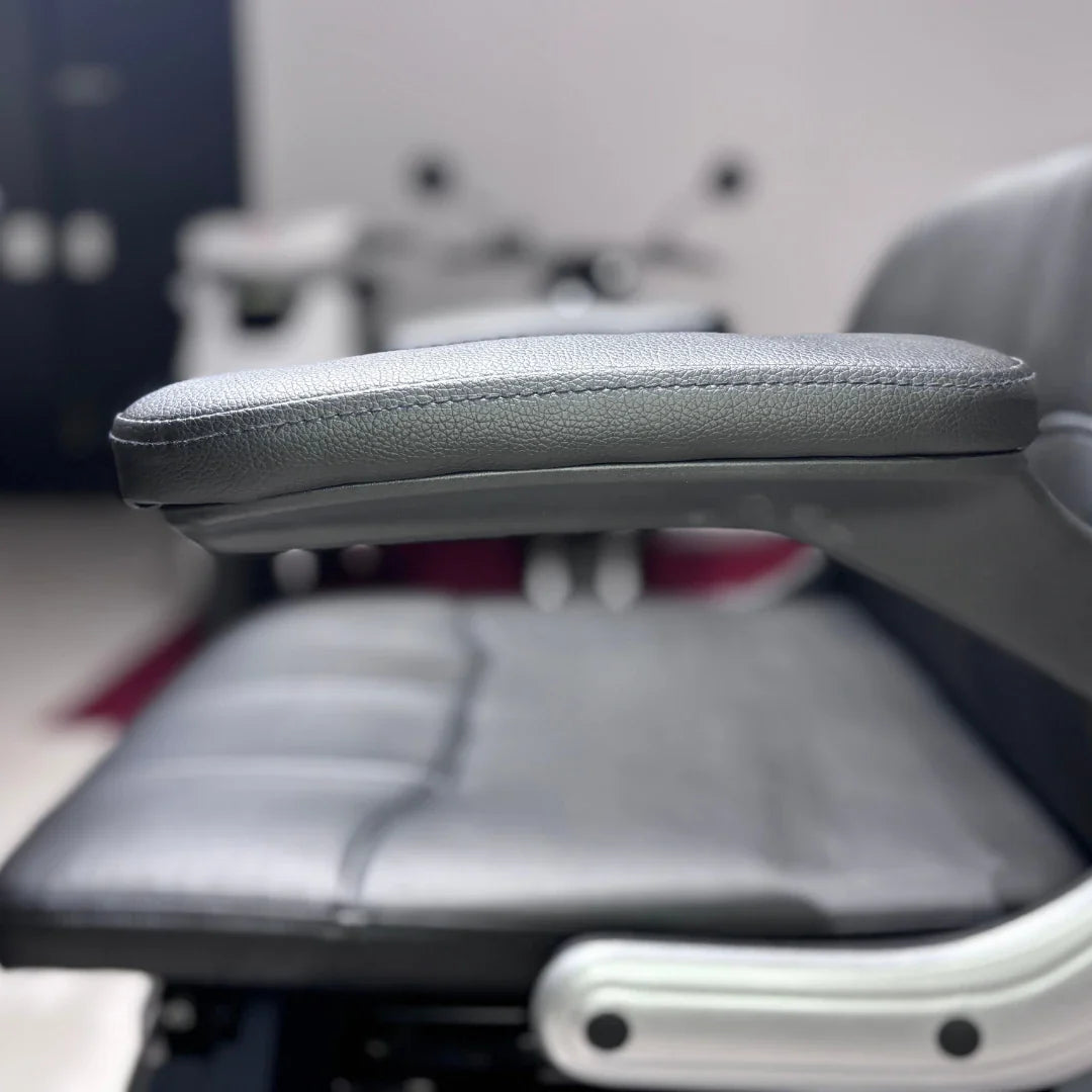 Izdelek je električni mobilni skuter, model Vigorous Vista Q1. Na sliki je prikazana ročno naslonjena na sedež, ki je oblazinjen s črnim umetnim usnjem. Sedež je širok in udoben, kar nakazuje na namen uporabe za daljše vožnje. V ozadju so vidni deli skuterja, kar nakazuje na njegovo celotno zasnovo.