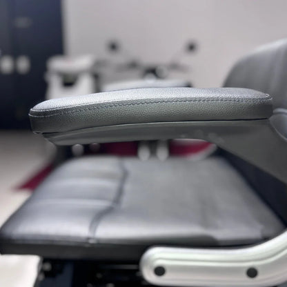 Izdelek je električni mobilni skuter, model Vigorous Vista Q1. Na sliki je prikazana ročno naslonjena na sedež, ki je oblazinjen s črnim umetnim usnjem. Sedež je širok in udoben, kar nakazuje na namen uporabe za daljše vožnje. V ozadju so vidni deli skuterja, kar nakazuje na njegovo celotno zasnovo.