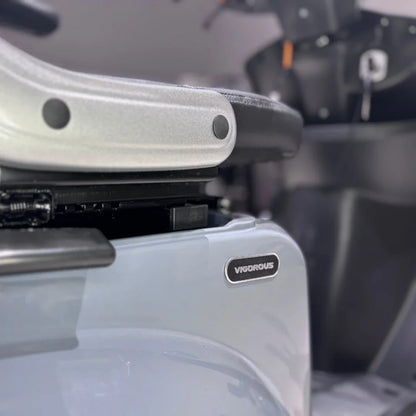 Izdelek je električni mobilni skuter, model Vigorous Vista Q1. Na sliki je del skuterja, kjer je vidna oznaka znamke "Vigorous" ter del sedeža in podvozja. Skuter je zasnovan za udobno vožnjo in mobilnost.