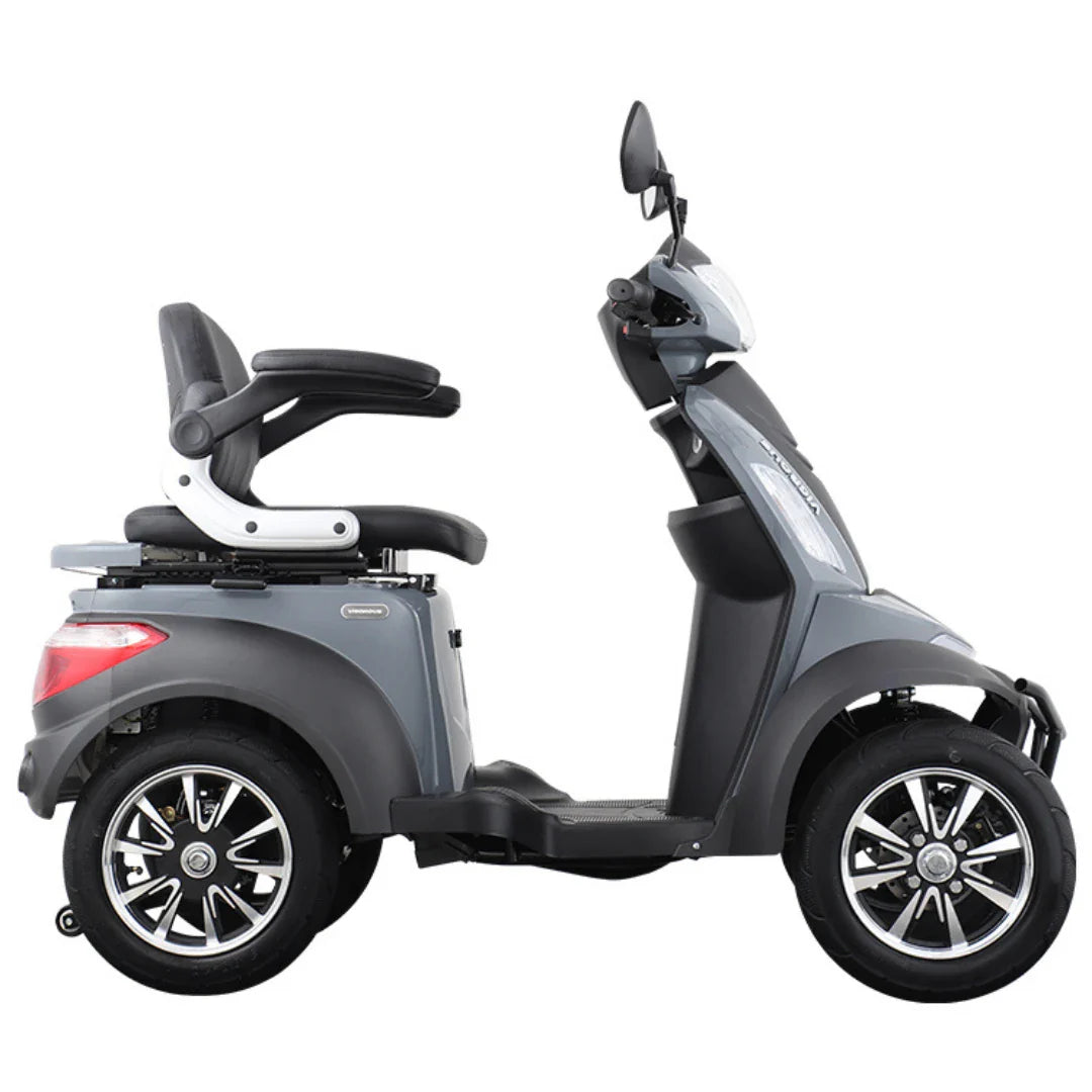 Na sliki je električni mobilni skuter, model Vigorous Vista Q1. Ima štiri kolesa, kar zagotavlja stabilnost, ter udoben sedež z naslonjalom. Na skuterju so vidni tudi ogledali in sodobna oblika, kar nakazuje na uporabnost za prevoz oseb, ki potrebujejo pomoč pri mobilnosti.