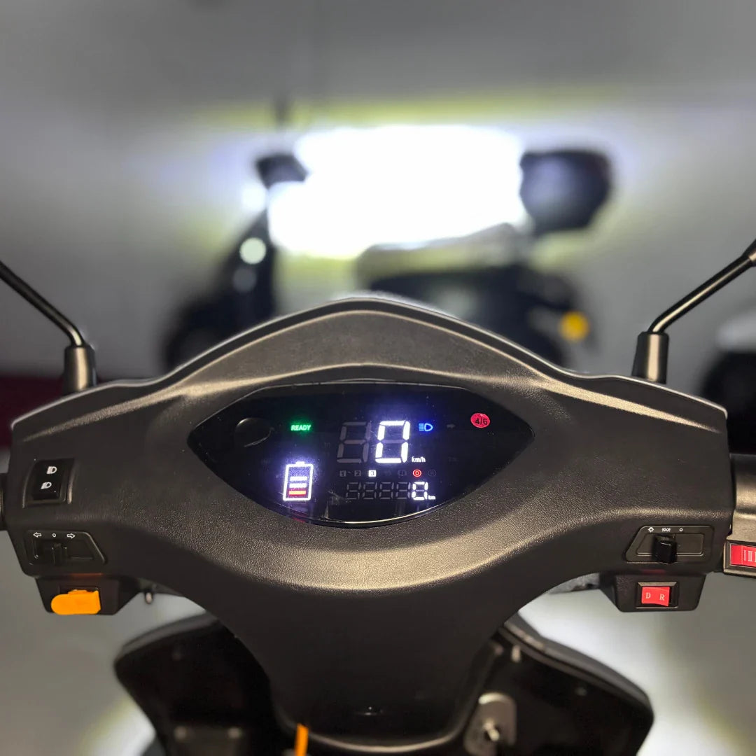 Izdelek je električni mobilni skuter, znamke Vigorous, model Vista Q1. Na sliki je prikazan nadzorni panel skuterja, ki vključuje digitalni zaslon s hitrostjo, nivojem baterije in drugimi funkcijami. Vidni so tudi ročaji in gumbi za upravljanje, kar nakazuje na enostavno uporabo.