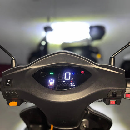 Izdelek je električni mobilni skuter, znamke Vigorous, model Vista Q1. Na sliki je prikazan nadzorni panel skuterja, ki vključuje digitalni zaslon s hitrostjo, nivojem baterije in drugimi funkcijami. Vidni so tudi ročaji in gumbi za upravljanje, kar nakazuje na enostavno uporabo.