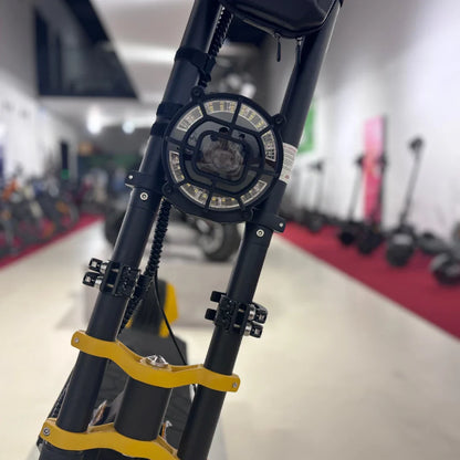 Izdelek na sliki je električni skiro, znamke Vsett, model 11 Super. Na sliki je vidna sprednja stran skiroja, kjer je nameščen močan LED žaromet in ojačitev na krmilu. V ozadju so vidni tudi drugi električni skiroji, kar nakazuje, da je slika posneta v prodajnem prostoru.