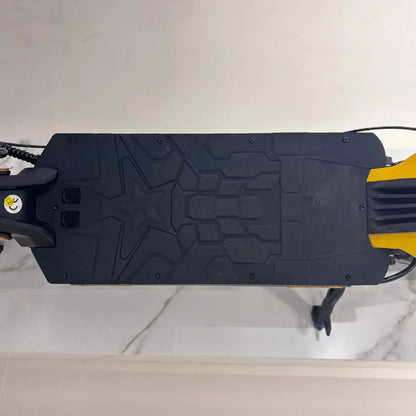 Izdelek na sliki je električni skiro, model Vsett 11 Super. Na sliki je vidna platforma skiroja, ki ima teksturirano površino za boljši oprijem, ter del okvirja v rumeni barvi. Viden je tudi del krmila in kabli, kar nakazuje na funkcionalnost in zasnovo skiroja.